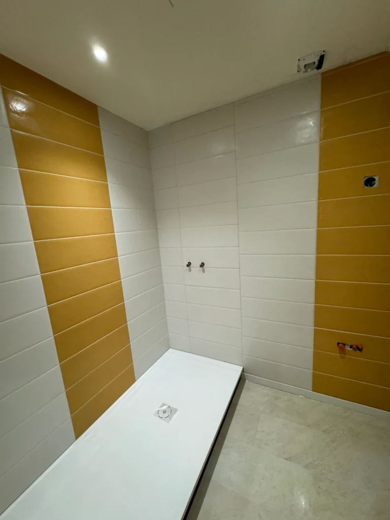Salle de bain faïence blanche bandes couleur receveur